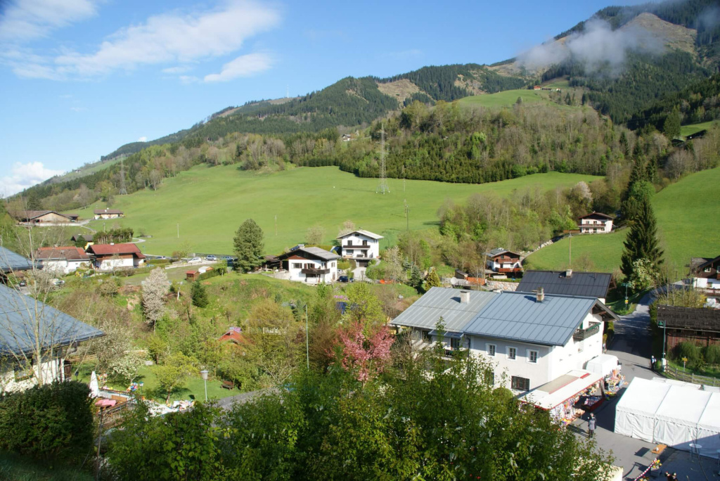Landschaft mit hügeligen Wiesen und Wohnhäusern in St. Georgen. Traditionelles Dorfbild.