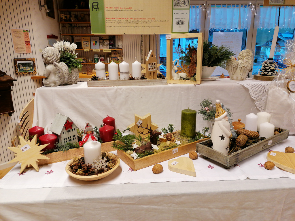 Weihnachtliche Dekorationen mit Kerzen und Holzfiguren auf Tisch