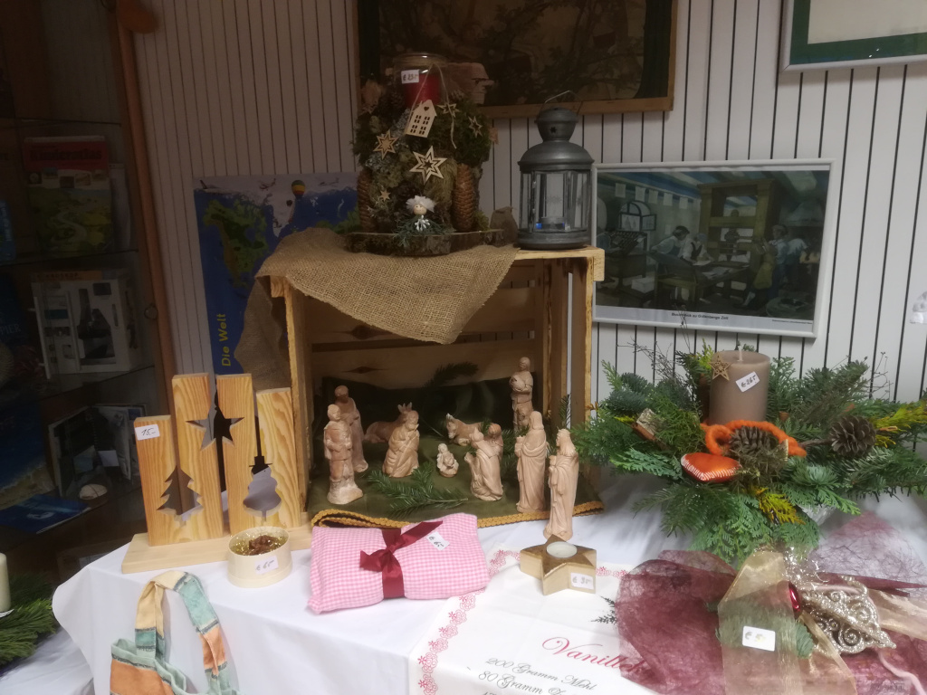 Weihnachtsdekoration und Krippe auf Tisch beim Adventbasar