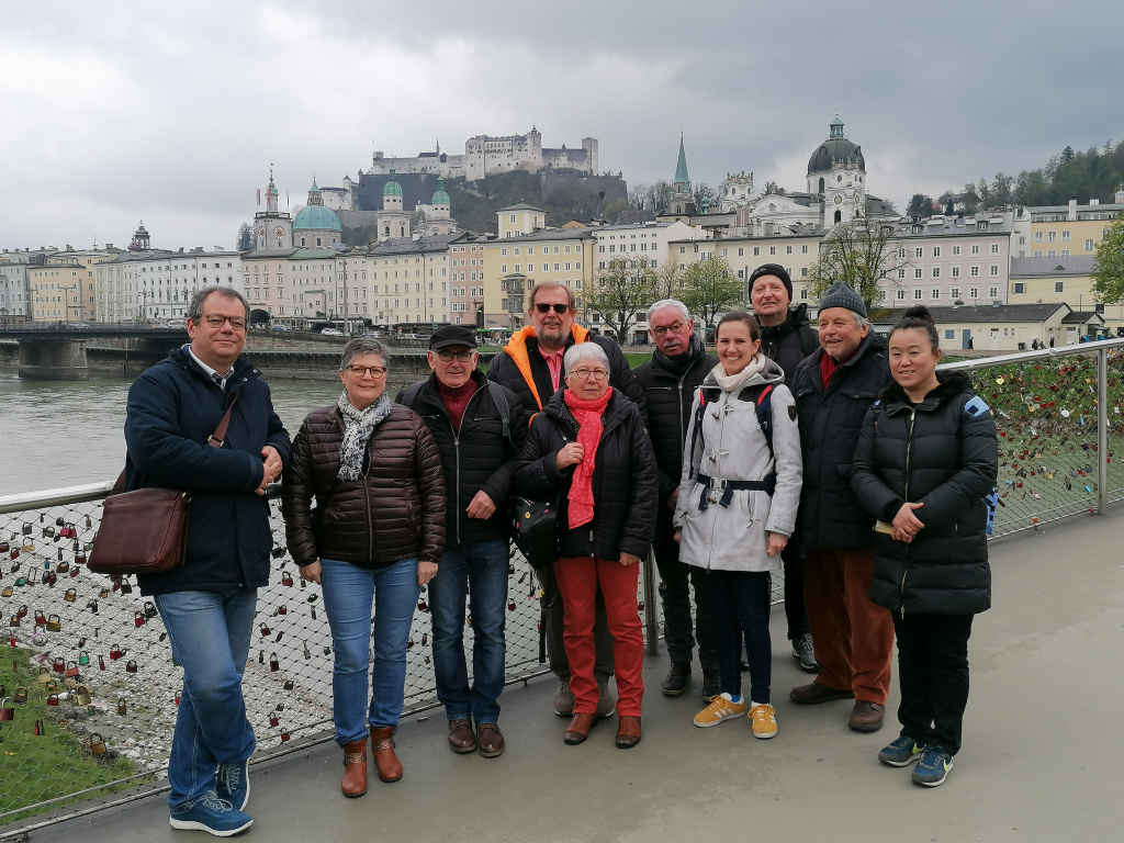 Gruppe von Menschen auf Brücke mit Blick auf Salzburg